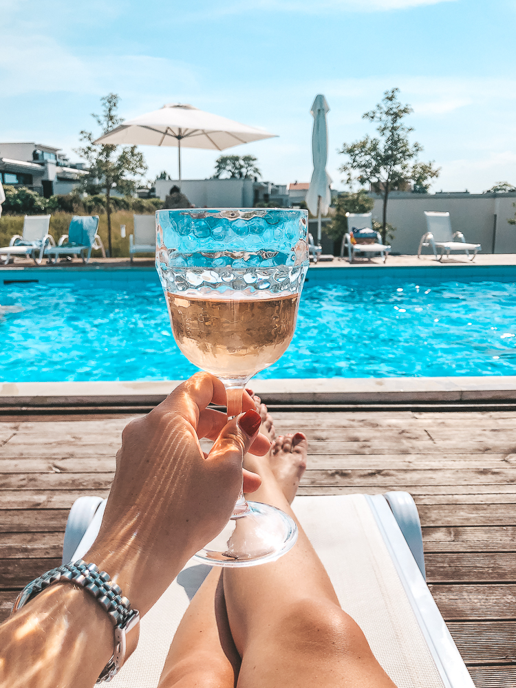 A picture of a woman enjoying a glass of wine by the pool at Gotland